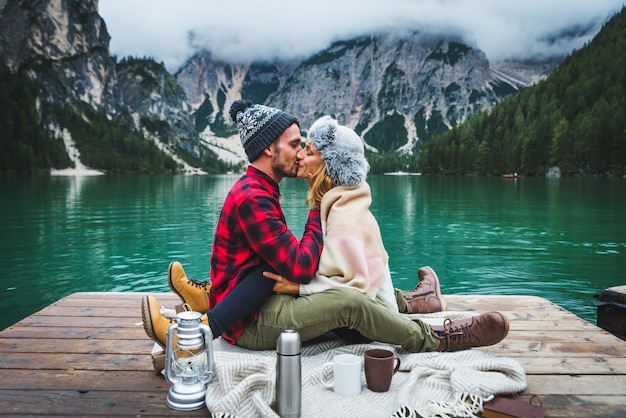 Bella coppia di giovani adulti che visitano un lago alpino a Braies Italia