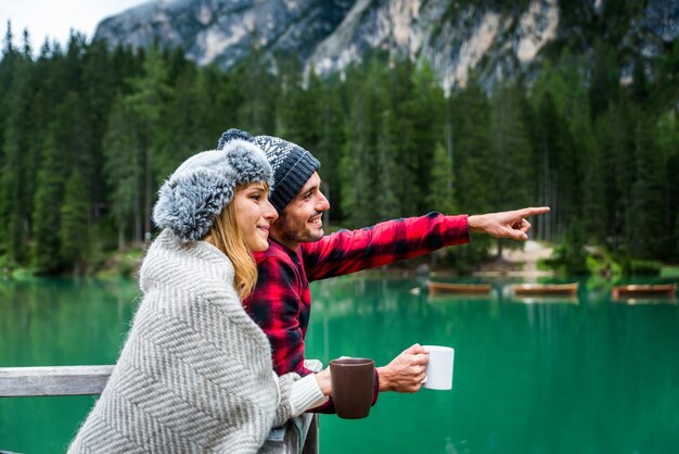 Bella coppia di giovani adulti che visitano un lago alpino a Braies Italia