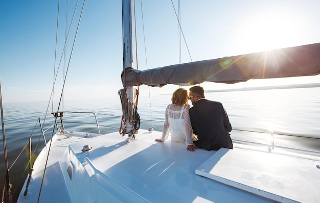 Bella coppia di nozze su yacht al giorno delle nozze all'aperto nel mare Insieme giorno delle nozze