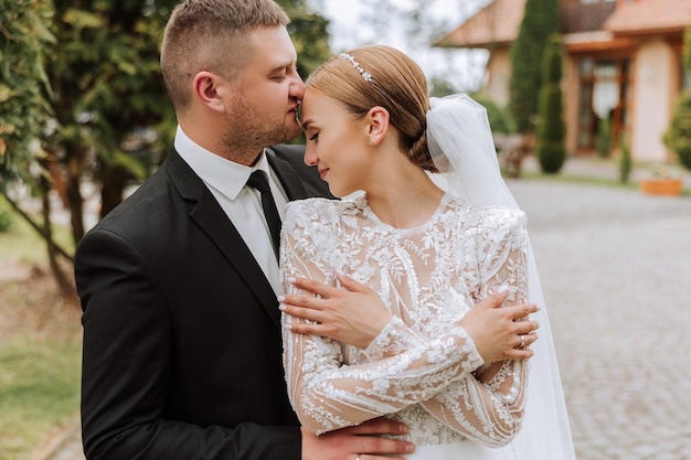 Bella coppia di sposi Lo sposo bacia la sposa sulla fronte