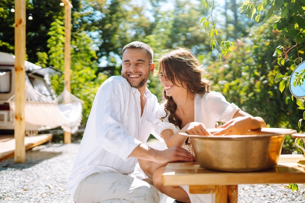 Bella coppia di sposi ridere e baciare rilassandosi in camper in campeggio in un rimorchio Momento romantico