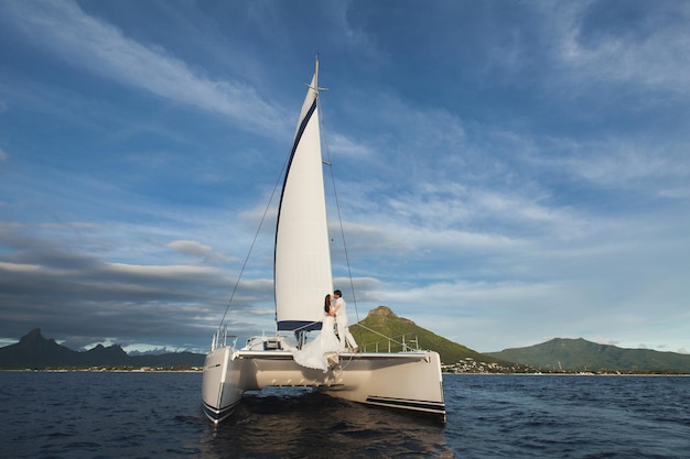 Bella coppia di sposi sposi su yacht al giorno delle nozze all'aperto nel mare