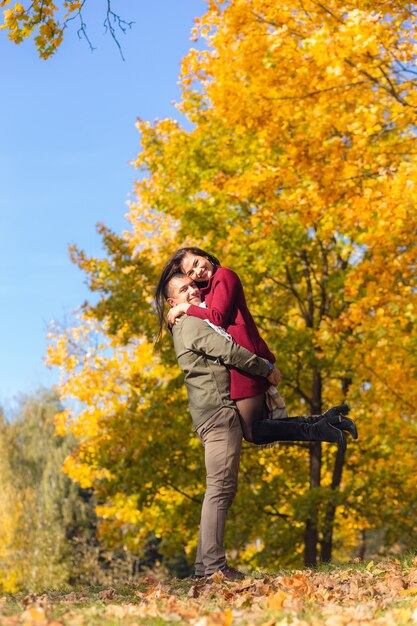 Bella coppia divertirsi insieme nella natura. Fidanzato che porta la sua ragazza tra le braccia.
