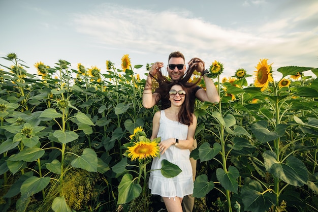 bella coppia divertirsi nel campo di girasoli