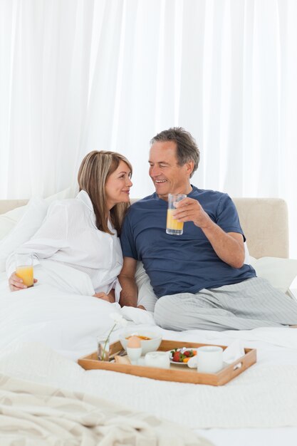 Bella coppia facendo colazione nel loro letto