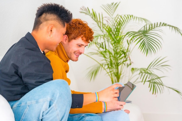 Bella coppia gay romantica sul divano che abbraccia il concetto lgbt facendo shopping online