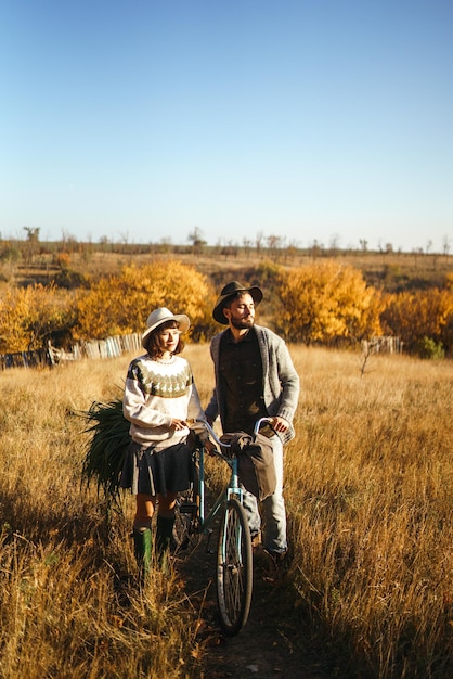 Bella coppia hipster con bici Coppia che indossa bei cappelli e maglioni Stile di vita