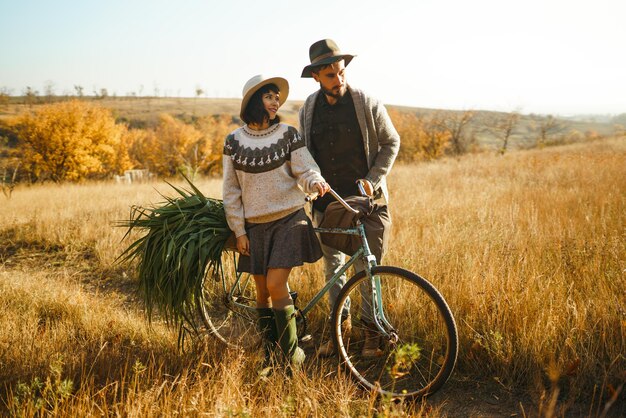 Bella coppia hipster con bici Coppia che indossa bei cappelli e maglioni Stile di vita