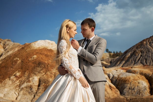 Bella coppia innamorata su un paesaggio favoloso, matrimonio nella natura, amore bacio e abbraccio.