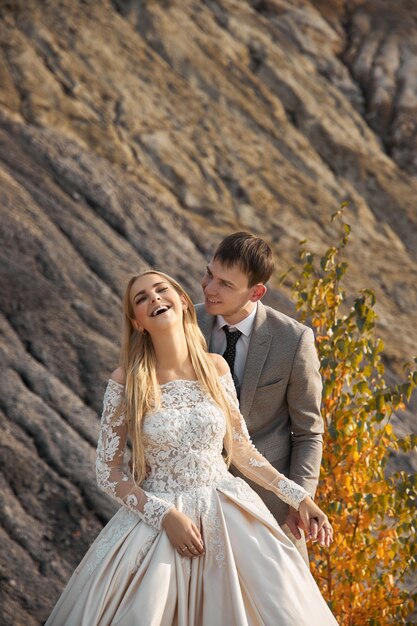 Bella coppia innamorata su un paesaggio favoloso, matrimonio nella natura, amore bacio e abbraccio.