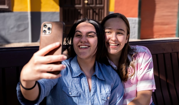 bella coppia lesbica che si ama per strada scattando foto con il telefono LGTB