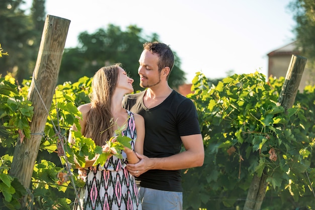 Bella coppia romantica uomo e donna giovani adulti che camminano insieme nei vigneti