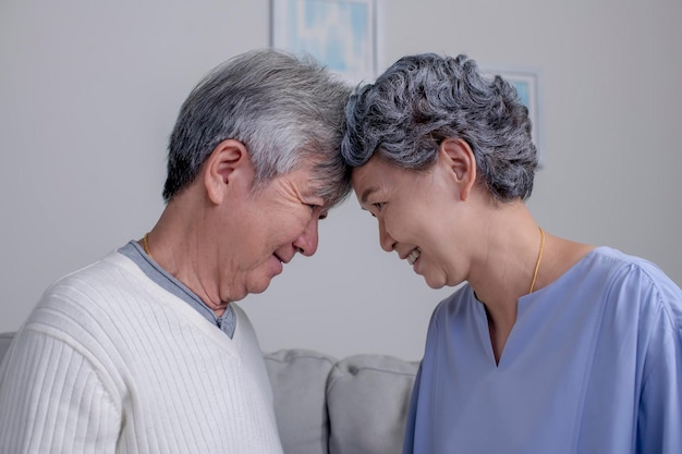 Bella coppia senior asiatica che si tocca faccia a faccia a casa Ritratto di uomo anziano romantico con sua moglie a casa