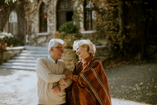 Bella coppia senior che si abbraccia nel parco autunnale