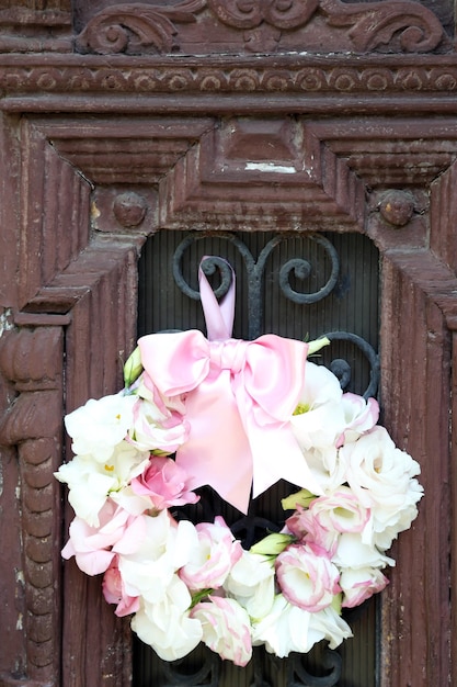 Bella corona di fiori appesa alla vecchia porta di legno