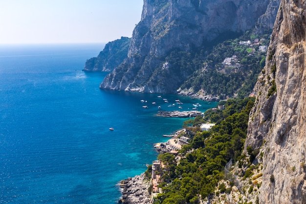 Bella costa rocciosa e barche sul mare in una giornata di sole estivo