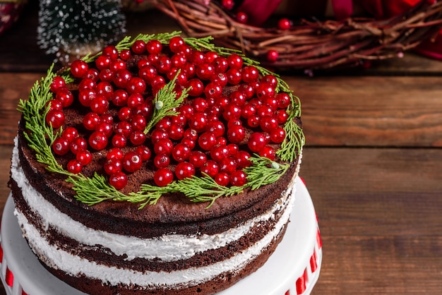 Bella deliziosa torta con bacche rosse luminose sul tavolo di Natale