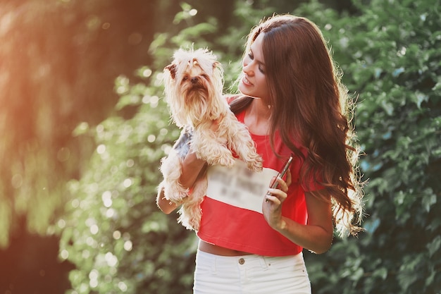 Bella donna a piedi con il cane nel parco.