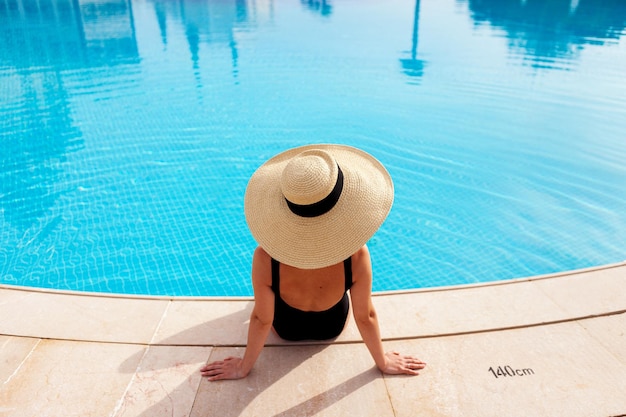 Bella donna a prendere il sole in piscina vista dall'alto orizzontale sfondo estate poster mock up per il design