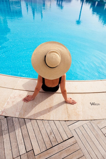 Bella donna a prendere il sole in piscina vista dall'alto orizzontale sfondo estate poster mock up per il design