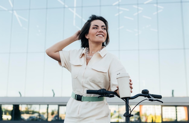 Bella donna adulta in posa con bici ecologica