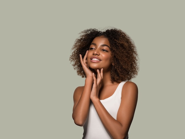 Bella donna africana bianca t-shirt ritratto taglio di capelli afro che tocca il suo viso Colore di sfondo verde