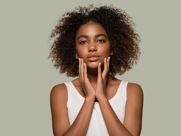 Bella donna africana bianca t-shirt ritratto taglio di capelli afro che tocca il suo viso Colore di sfondo verde