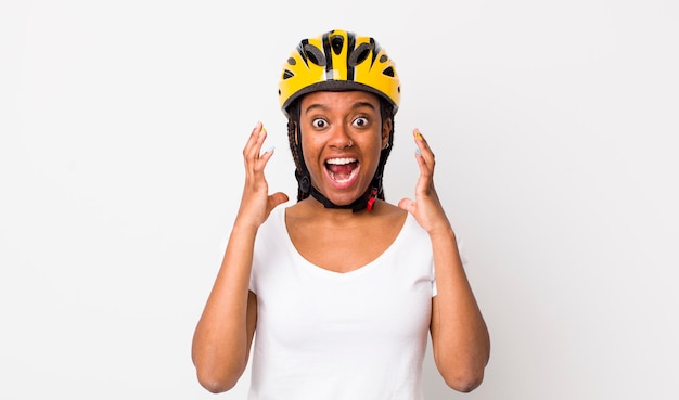 Bella donna afro con trecce con un casco da bici