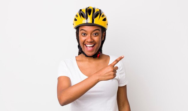 Bella donna afro con trecce con un casco da bici