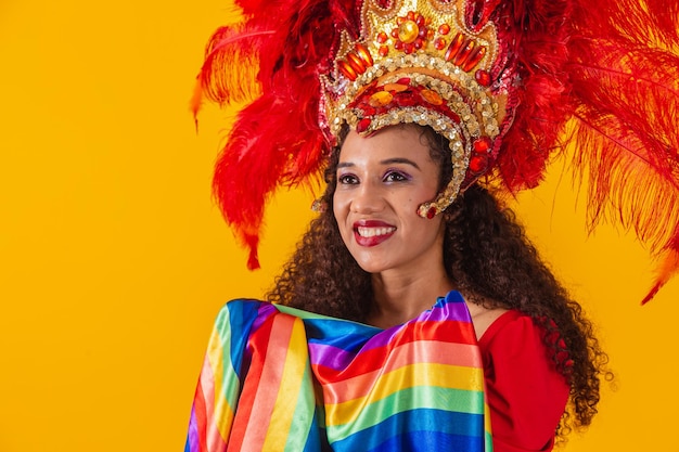 Bella donna afro in abito di carnevale bandiera lgbt su sfondo giallo.