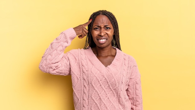 Bella donna afro nera che si sente confusa e perplessa, mostrando che sei pazzo, pazzo o fuori di testa