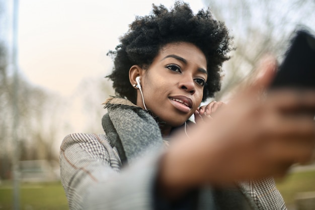 Bella donna afro prendendo un selfie