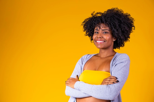 Bella donna afroamericana che guarda l'obbiettivo Ritratto di giovane donna allegra con acconciatura afro Ragazza di bellezza con le braccia incrociate dei capelli ricci