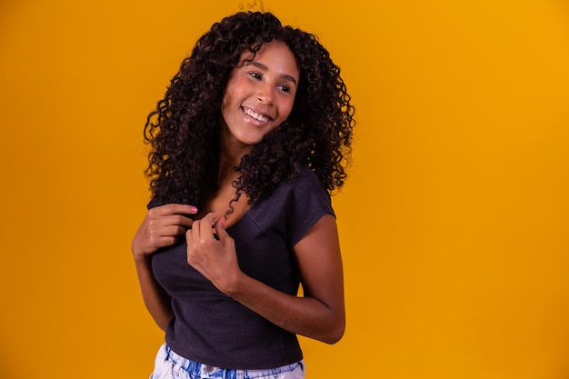 Bella donna afroamericana guardando la fotocamera Ritratto di giovane donna allegra con acconciatura afro Ragazza di bellezza con i capelli ricci