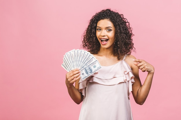 Bella donna afroamericana sorpresa in vestito che tiene soldi