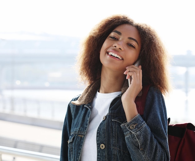 Bella donna afroamericana utilizzando il cellulare in strada