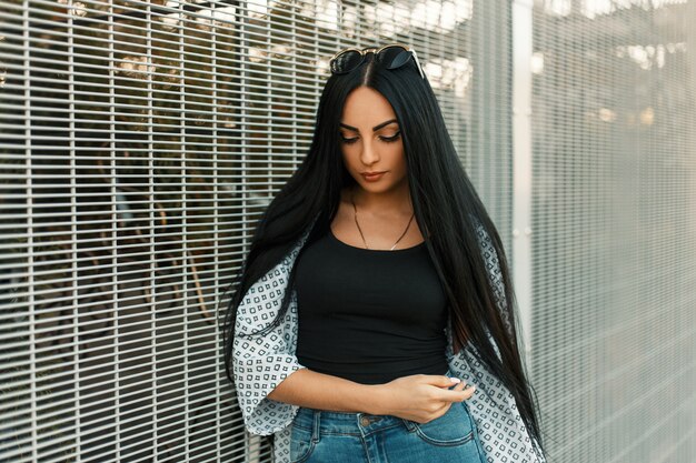 Bella donna alla moda con i capelli lunghi con occhiali da sole vintage