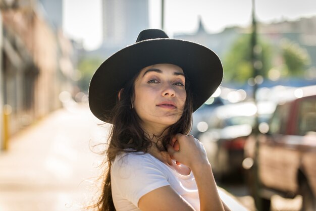 Bella donna alla moda dell'adolescente che posa con il cappello