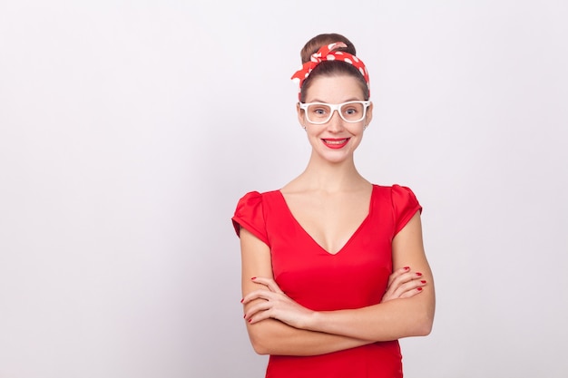 Bella donna allegra in abito rosso e occhiali bianchi sorridenti
