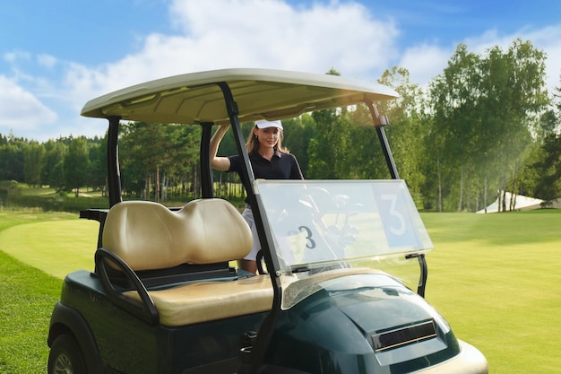 Bella donna allegra in piedi vicino nel carrello da golf.