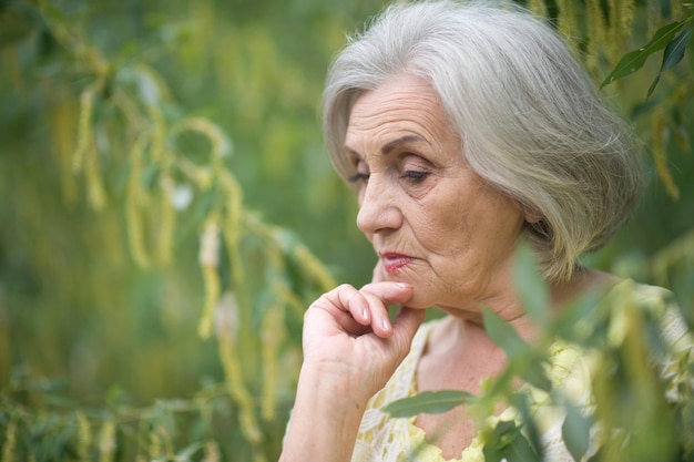 Bella donna anziana triste nel parco di primavera