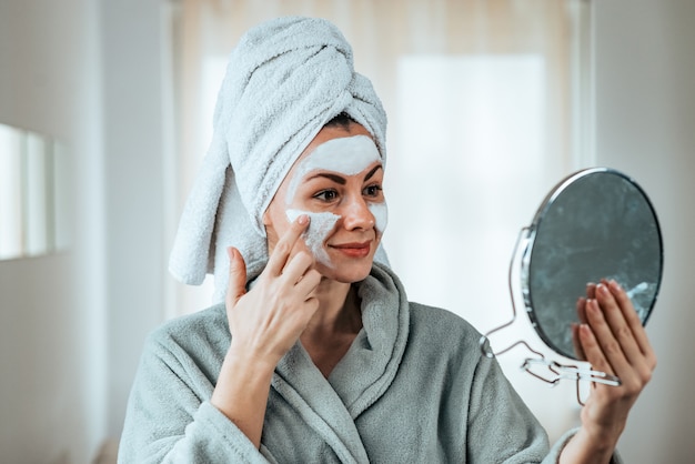 Bella donna applicando la maschera.