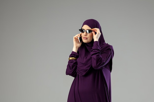 Bella donna araba che posa in hijab alla moda isolato su studio