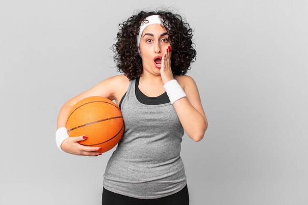 Bella donna araba che si sente scioccata e spaventata e tiene in mano una palla da basket. concetto di sport