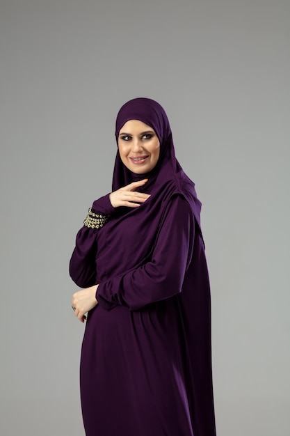 Bella donna araba in posa in elegante hijab isolato su sfondo per studio. Concetto di moda