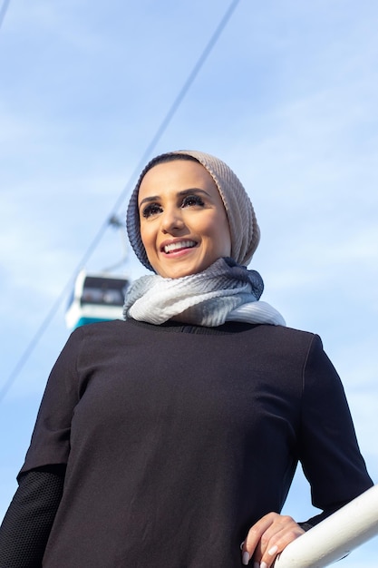 Bella donna araba sorridente in copricapo. Ritratto di donna con la testa coperta e trucco in attesa con un sorriso luminoso. Concetto internazionale e bello