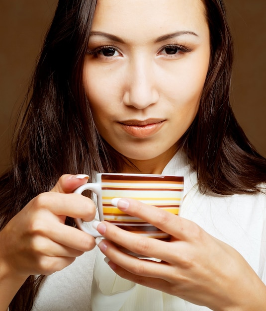 Bella donna asiatica che beve caffè o tè