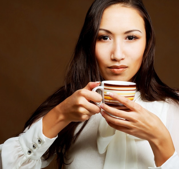 Bella donna asiatica che beve caffè o tè