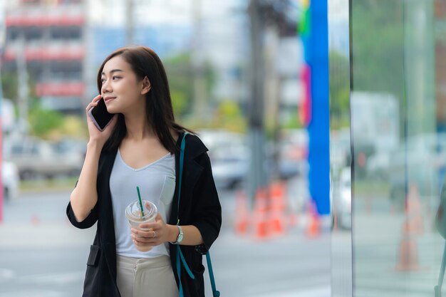 Bella donna asiatica che cammina per andare al lavoro Giovane donna d'affari di successo in una grande città