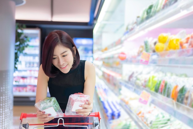 Bella donna asiatica che cammina per fare shopping in un supermercato Tempo per rilassarsi Acquista per cena Persone della Thailandia Concetto di stile di vita felice